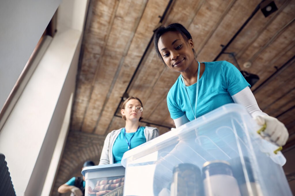 Volontärer packar lådor (underifrånperspektiv) Volontärer packar lådor med tillhörigheter sett underifrån.